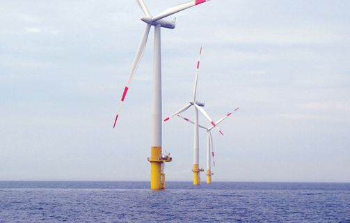 Three windmills at sea