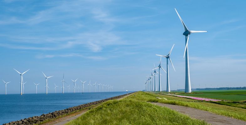 Offshore Windmill farm in the ocean Westermeerwind park, windmills isolated at sea on a beautiful bright day Netherlands Flevoland Noordoostpolder. Huge windmill turbines