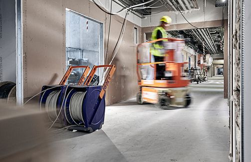 Installer pulling low-voltage cable from a Qaddy®