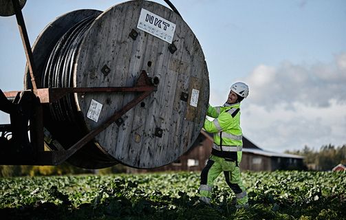 Cable worker pulling medium voltage cable from a drum