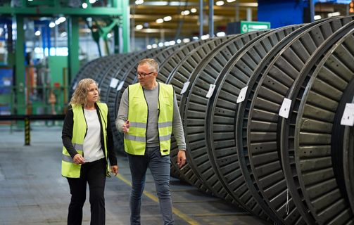 employees discussing and talking in production hall in front of cable drums